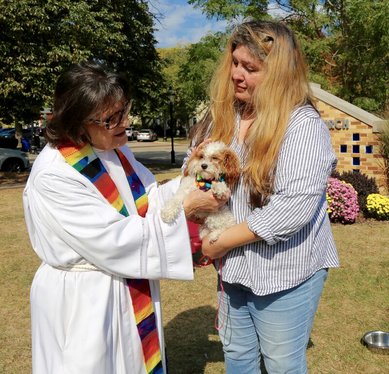 Pastor Jane Perkolup gives a blessing to Ava, a teacup poodle, as her owner Cici Ruby looks on, at the Blessing of the Animals that was held at Geneva Lutheran Church on Saturday, Oct. 5, 2024.