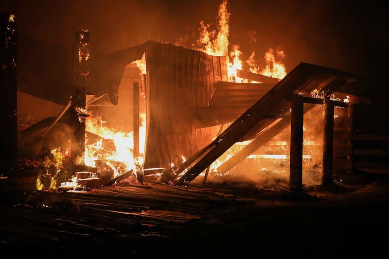 Firefighters battle a blaze at a barn near Harvard on June 9, 2025, that killed six horses.