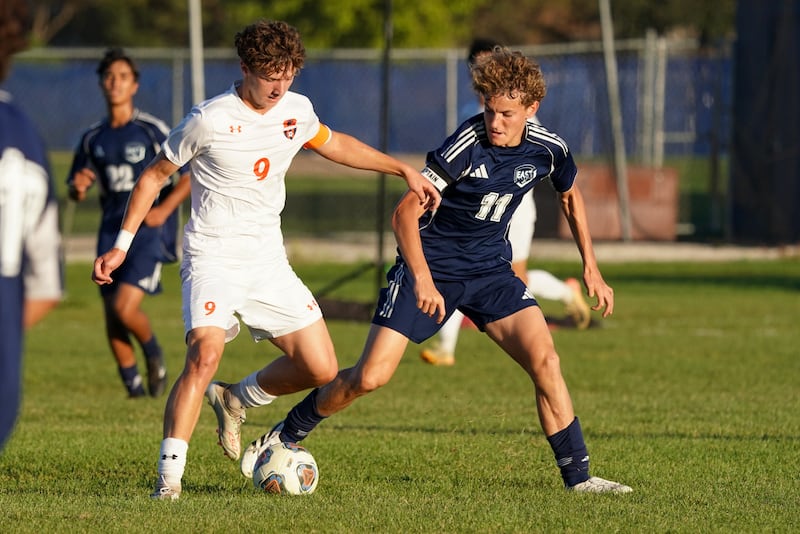 Oswego’s Dustin King (9) plays the ball against Oswego East's Vakaris Majus (11) during a Southwest Prairie Conference game at Oswego East High School on Thursday, Sept. 25, 2025.