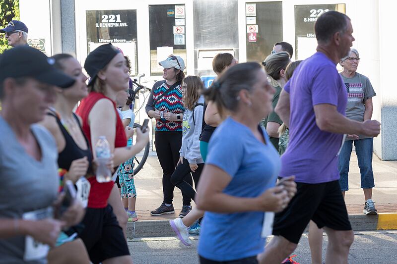 Spectators watch and cheer as a group of runners pass the Dixon library during the Reagan Run Saturday, July 6, 2024.