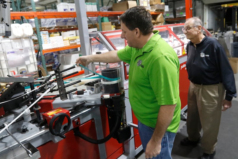 Guy Spinelli (right) and his son, Andy, of Boss Straw, as he explains how paper straws a made on Wednesday, March 12, 2025, in Woodstock The company manufactures paper straws and has been hit hard by the federal government switching back to plastic straws.