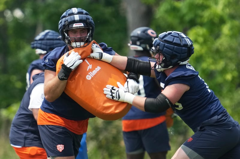 Chicago Bears offensive line Ozzy Trapilo, left, works with offensive line Theo Benedet during practice at NFL football minicamp at Halas Hall in Lake Forest, Ill., Tuesday, June 10, 2025. (AP Photo/Nam Y. Huh)