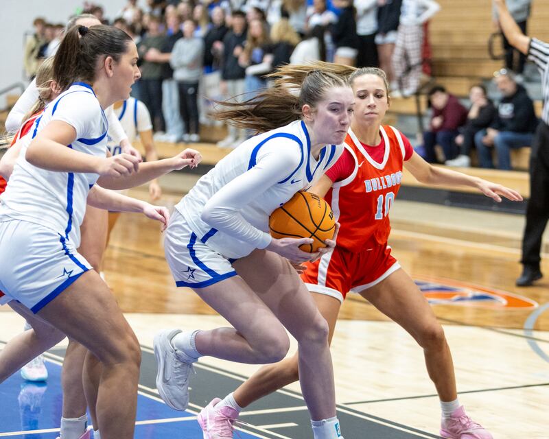 St. Charles North's Bronwyn How pulls down the rebound in front of Batavia's Payton Haslett on Friday, Dec.12,2025 in st. Charles.