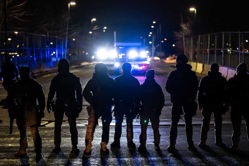 FILE - Federal officers stand guard after detaining people outside of Bishop Henry Whipple Federal Building, Jan. 13, 2026, in Minneapolis. (AP Photo/Adam Gray, File)