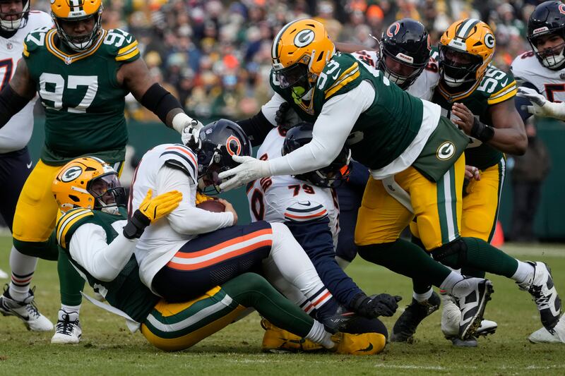 Green Bay Packers defensive end Rashan Gary, bottom left, tackles Chicago Bears quarterback Caleb Williams, middle left, during the first half of an NFL football game, Sunday, Jan. 5, 2025, in Green Bay, Wis. (AP Photo/Morry Gash)
