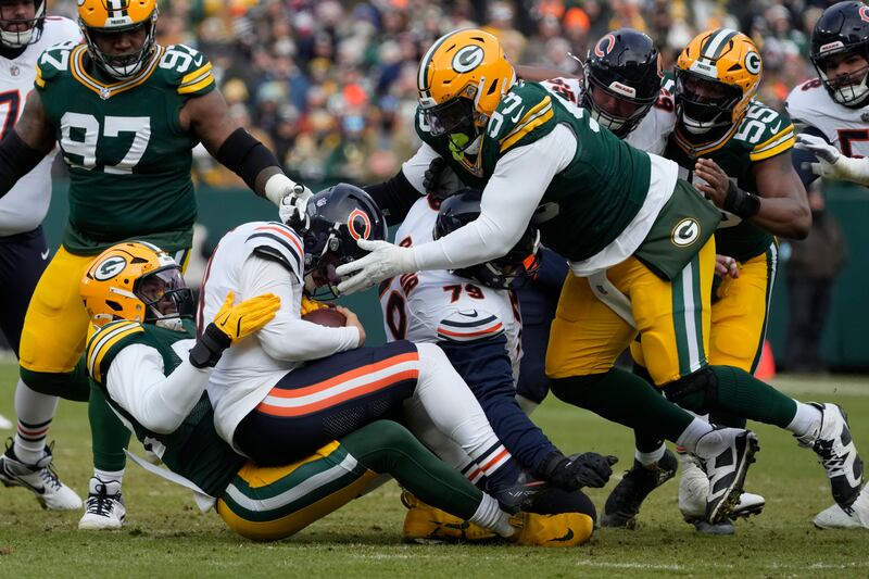 Green Bay Packers defensive end Rashan Gary, bottom left, tackles Chicago Bears quarterback Caleb Williams, middle left, during the first half of an NFL football game, Sunday, Jan. 5, 2025, in Green Bay, Wis. (AP Photo/Morry Gash)
