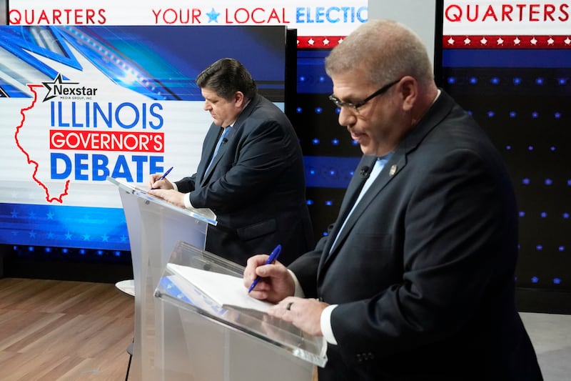 Illinois Gov. JB Pritzker, left, and Republican gubernatorial challenger state Sen. Darren Bailey prepare for the Illinois governor's debate at the WGN9 studios Tuesday, Oct. 18, 2022, in Chicago. (AP Photo/Charles Rex Arbogast)