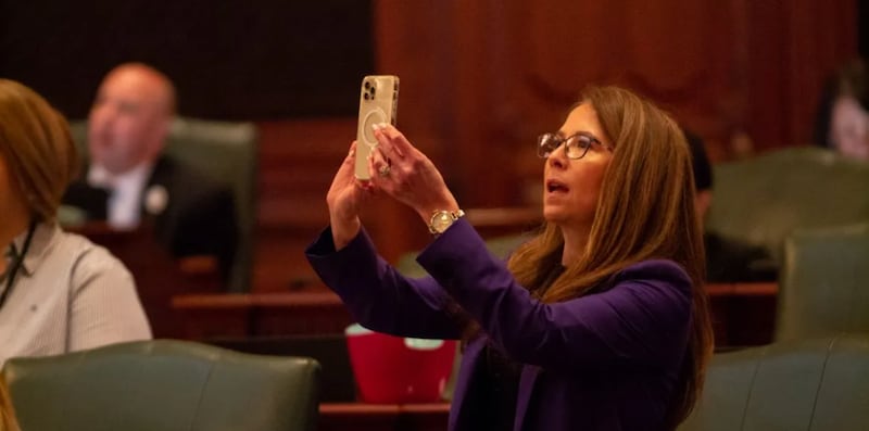 Rep. Jennifer Gong-Gershowitz, D-Glenview, takes a picture of the vote board in the Illinois House after the passage of a bill in May 2023.