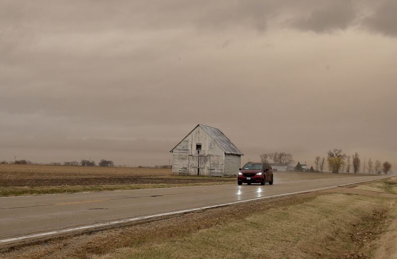 A view of a sepia colored sky next to a barn on Route 251 on Wednesday, March 19, 2025, in Peru. "Dirty rain" caused by wind and smoke from the West.