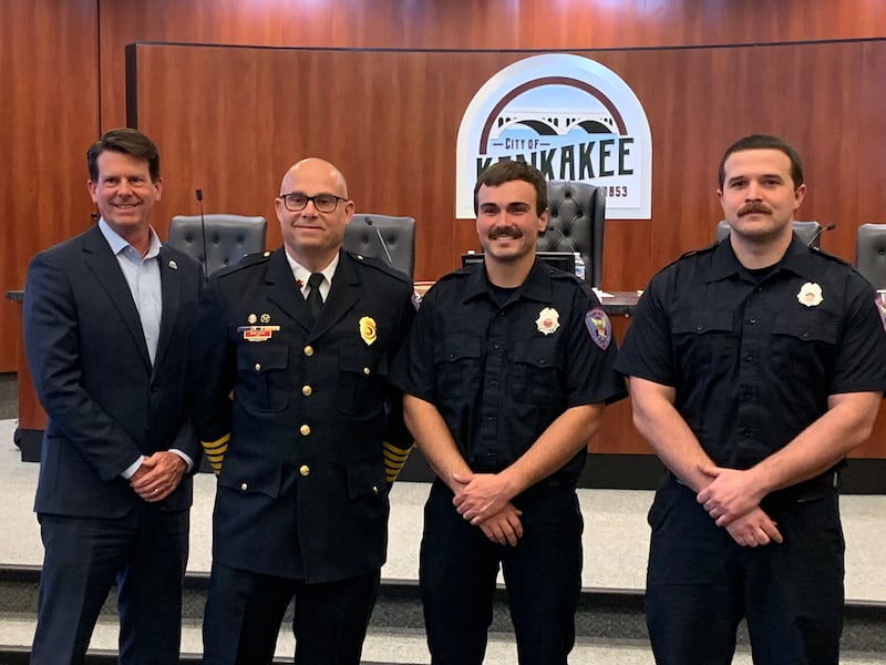 New Kankakee Fire Department officers Matthew Stichnoth, right, and Collyn Puddicombe, second from right, stand next to Kankakee Fire Chief Bryan LaRoche and Kankakee Mayor Chris Curtis during the April 20, 2026, city council meeting.