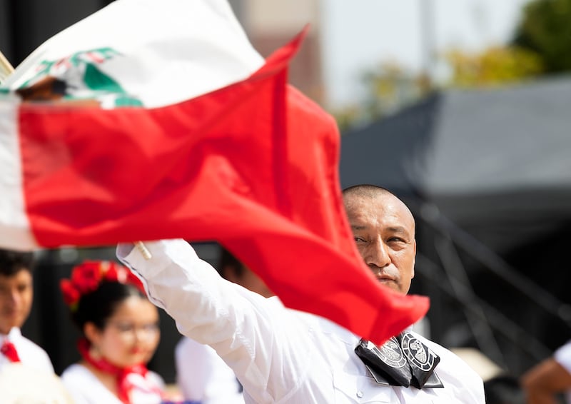 Roberto Flores of Sterling waves the Mexican flag during the Mexican national anthem Saturday, Sept. 13, 2025, at the start of Taste of Fiesta in Rock Falls.