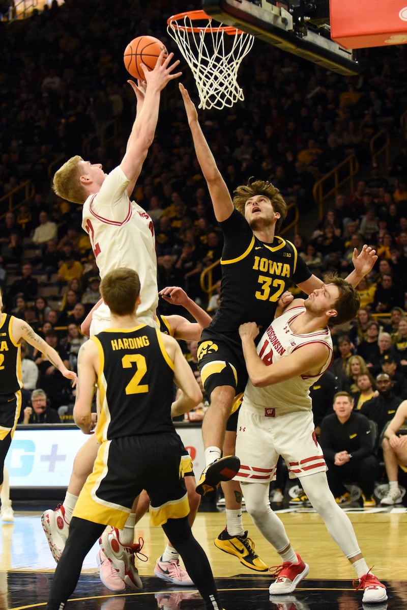 Iowa's Owen Freeman (32) attempts to block a shot from Wisconsin's Steven Crowl during an NCAA men's basketball game at Carver-Hawkeye arena at the University of Iowa Saturday, Feb. 17, 2024.