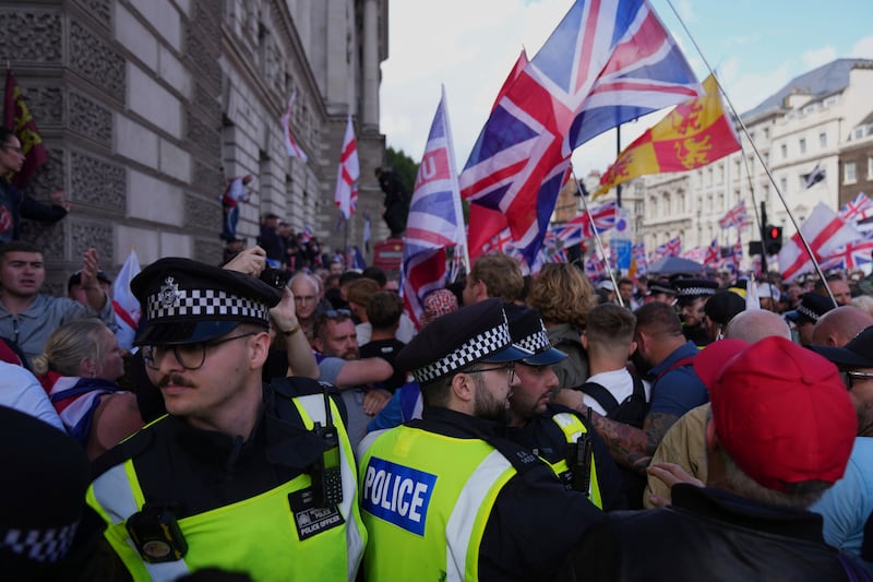 Police officers form a line in front of demonstrators from the Tommy Robinson-led Unite the Kingdom march and rally near Westminster, London, Saturday Sept. 13, 2025. (AP Photo/Joanna Chan)