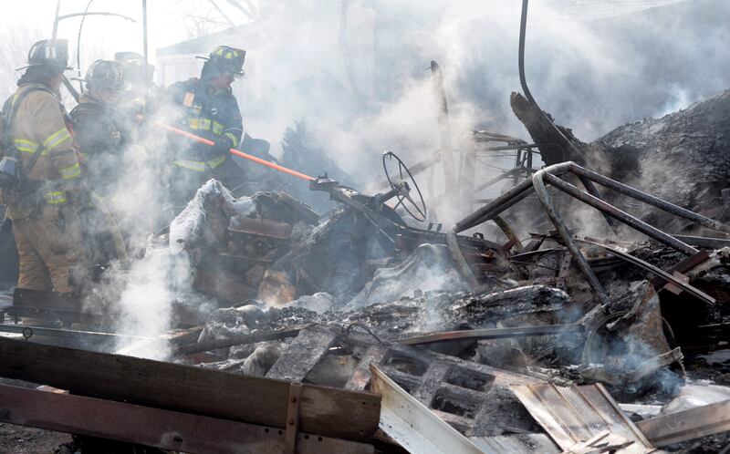 Firefighters look for hot spots near a burned out Jeep while responding to a garage fire at 6727 W. Henry Road, southeast of Polo, on Wednesday, March 26, 2025. Several departments responded to the fire at the rural residence. In addition to the Jeep, a camper and other items located inside and around the garage were destroyed. No injuries were reported.