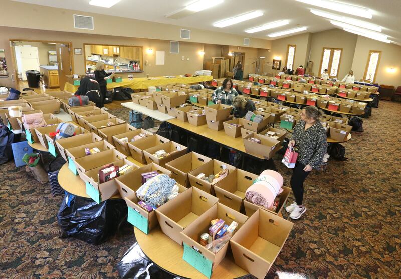 Volunteers fill baskets on Thursday, Dec, 14, 2023 at the Putnam County Food Pantry in Granville. In collaboration with Toys in the Pantry, organizations, businesses, churches and schools from across the county the pantry is distributing over 100 Christmas baskets to local families in need. This is the 36th year the pantry has sponsored the basket project. The baskets contain food and gifts for children and senior citizens.