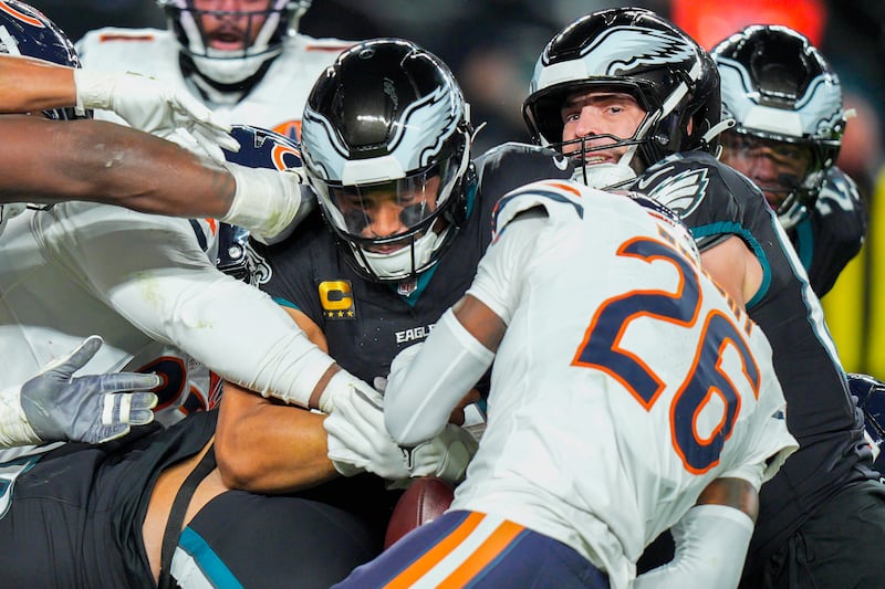 Chicago Bears cornerback Nahshon Wright (26), right, gets the ball from Philadelphia Eagles quarterback Jalen Hurts (1) on the tush push during the second half of an NFL football game, Friday, Nov. 28, 2025, in Philadelphia. (AP Photo/Chris Szagola)