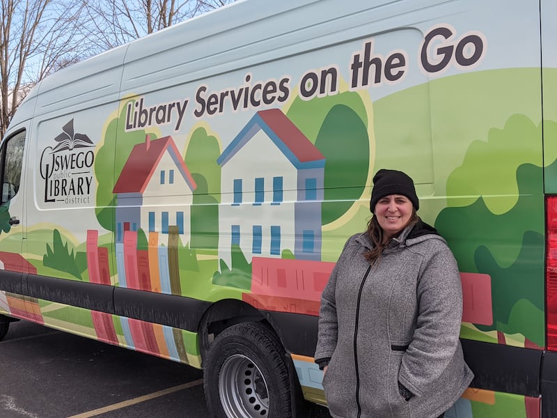 Oswego Public Library District Director Krista Katzen stands in front of the district's new outreach vehicle.