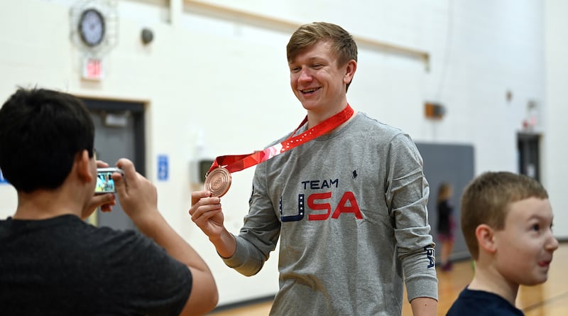 Ethan Cepuran, of Glen Ellyn poses in 2022 with the bronze medal he earned at the 2022 Olympic Winter Games in Beijing. Cepuran, a speed skater, stopped by his hometown with three fellow Olympians. “There’s no point in doing a sport if you can’t inspire the next generation,” Cepuran said. “Winning the medal was amazing but you get to relive that moment every time you share it with a kid.”