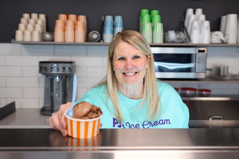 Tara Robinson, of Peotone, serves up a scoop of a customer favorite, Michigan Pot Hole, at PJ's Ice Cream in Manteno. Robinson, the new owner of the shop at 41 W. Second St., is no stranger to the business as she and her family have visited for years.
