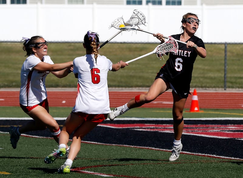 Huntley's Leah Holmberg (right) takes a shot on goal as Barrington's Emma Martin (left) and Cecilia Babel defend during the Huntley Supersectional girls lacrosse match on Tuesday, June 2, 2026, at Huntley High School.