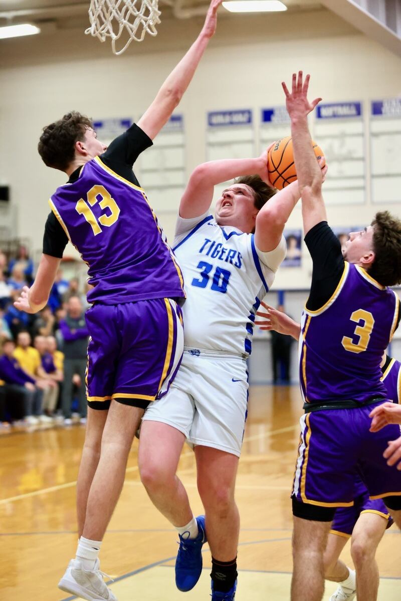 Mendota's Drew Becker (13) and Cam Kelly (3) put the squeeze on Princeton's Jordan Reinhardt during the second half of Wednesday's regional semifinal contest at Prouty Gym. The Tigers won 54-47.