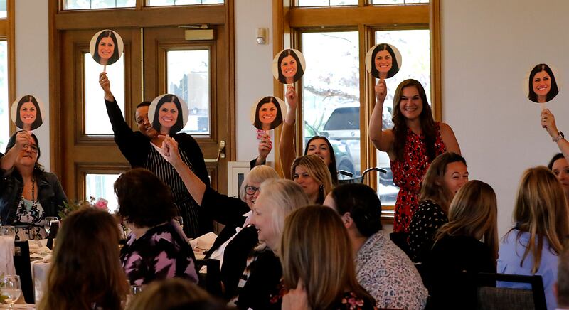 Supports hold up signs of award recipient Kristin Schmidt before she speaks during the Northwest Herald's Women of Distinction award luncheon Wednesday June 4, 2025, at Boulder Ridge Country Club, in Lake in the Hills. The luncheon recognized ten women in the community as Women of Distinction.