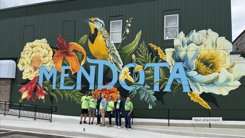 Members of Reimagine Mendota posing with Audrey Carver in front of her mural at its dedication ceremony in downtown Mendota at 728 Main St.