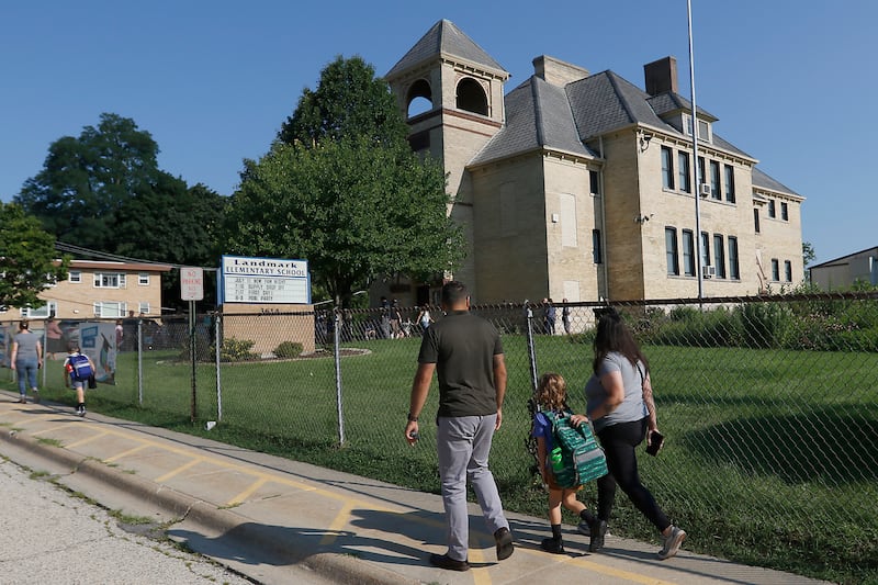 A family walks towards Landmark Elementary School on Wednesday, July 17, 2024, for the first day of school at McHenry’s year-round elementary school.