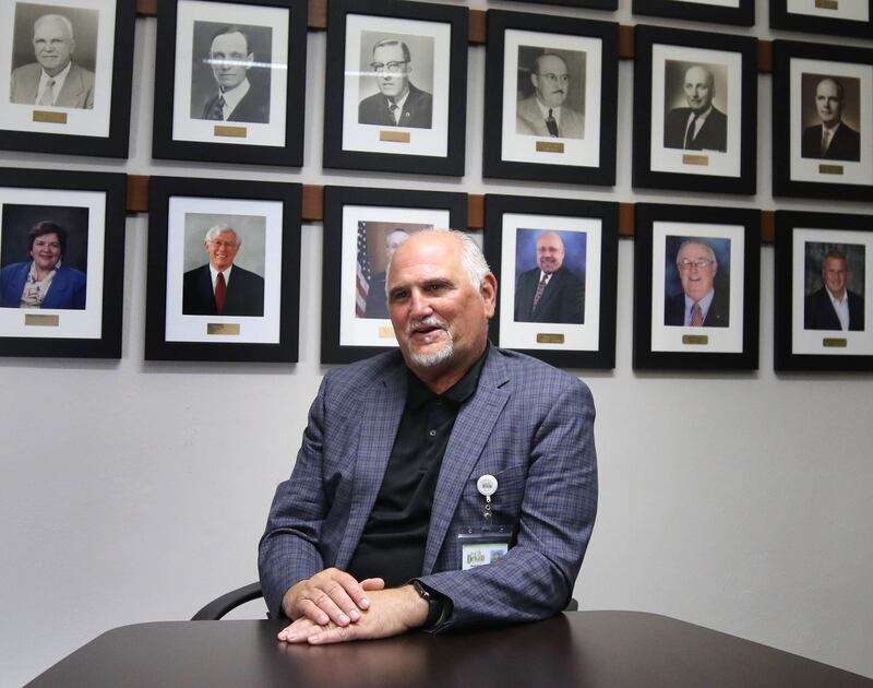 Bradley Hoey, flanked by portraits of past DeKalb mayors, talks Tuesday, Aug. 19, 2025, about how it has gone since he was first sworn into office as DeKalb City Clerk nearly 100 days ago.