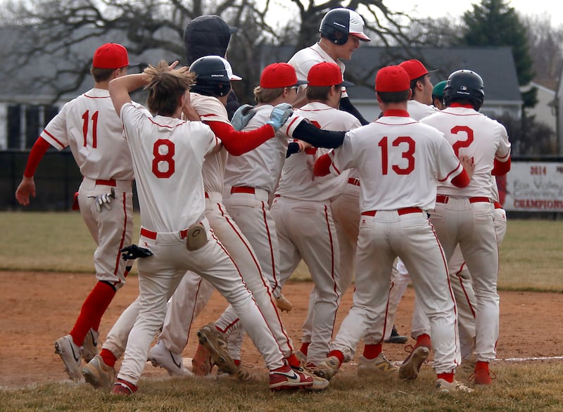 Huntley players mug Huntley's Joey Lengle after his walk in the ninth inning scored a run to win a nonconference baseball game against Fremd on Tuesday, March 24 2026, at Huntley High School.