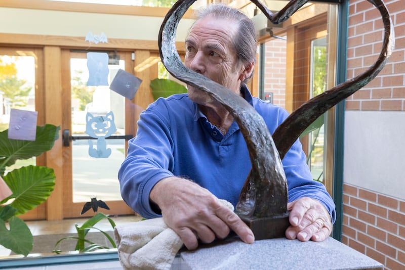 Artist Mike McNamara checks the positioning of his work Monday, Oct. 20, 2025, in Franklin Grove. A sculpture dedicated to Winifred Knox is being put into place at the library.