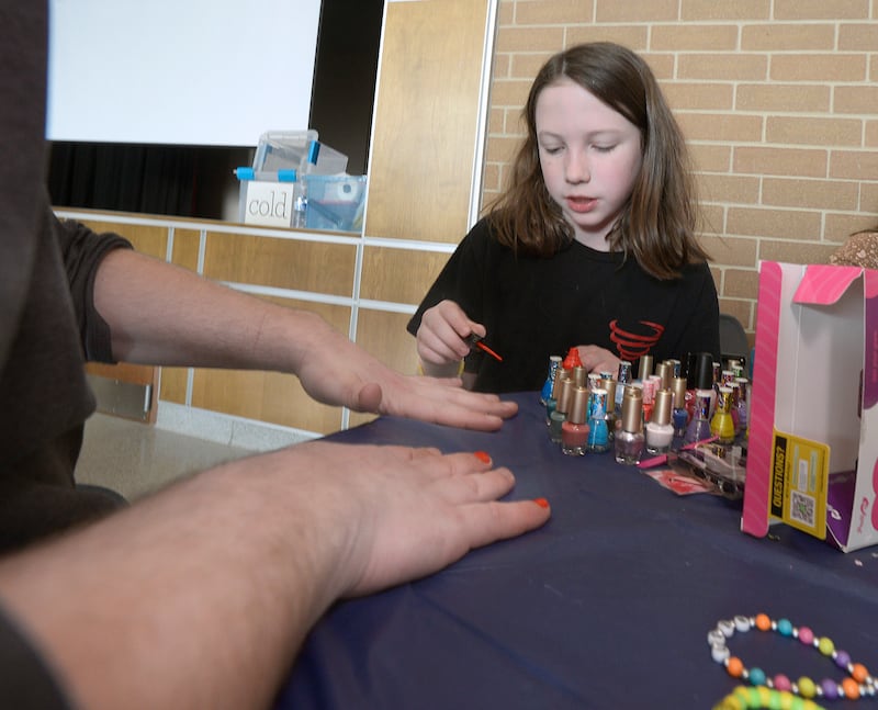 Marlena Vacca decorates the finger nails of a client Wednesday, April 16, 2025, during the Central Intermediate School Lemonade Day My Way in Ottawa.