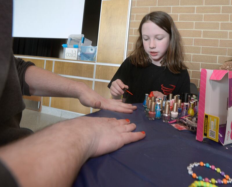 Marlena Vacca decorates the finger nails of a client Wednesday, April 16, 2025, during the Central Intermediate School Lemonade Day My Way in Ottawa.
