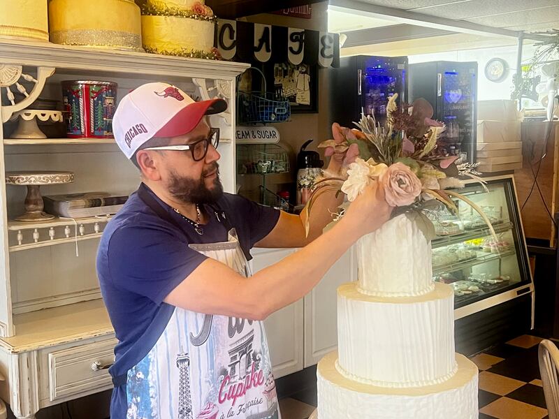 Owner Aurelio Gallardo arranges flowers atop a cake inside Aurelio's Bake Shop & Coffee House at 517 Locust St. in Sterling.