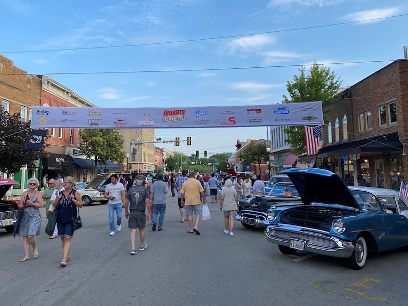 A crowd of people looks at the cars as they wander down Liberty Street during Morris Cruise Night.