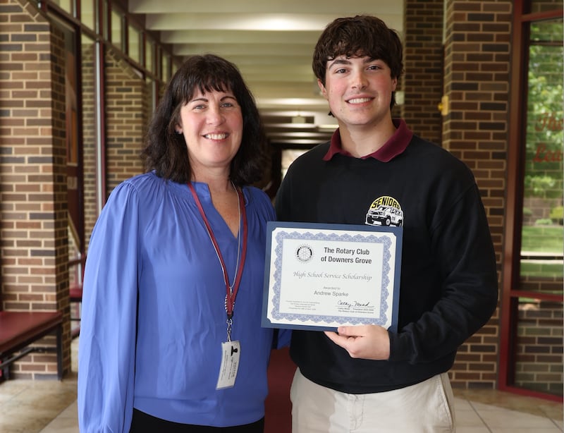 Downers Grove Rotary Club President Catherine Mead congratulates Andrew Sparke on receiving the organization's Service Scholarship