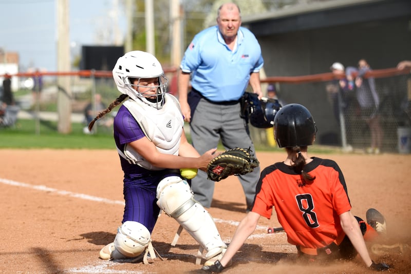 Wilmington catcher Madisyn Rossow, left, looks to corral a throw into home plate as Beecher's Elena Kvasnicka slides in for a run during a game at Beecher Thursday, April 24, 2025.