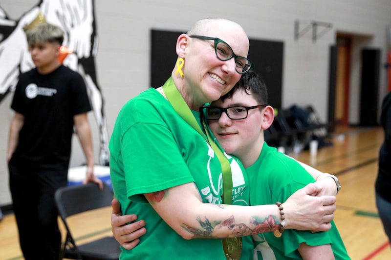 Martin Elementary School special education teacher Jennifer Slad embraces her former student, Matthew Erickson, after her head was shaved at Marlowe Middle School in Huntley for a St. Baldrick’s Foundation fundraiser. Slad shaves her head in honor of Matthew, who is a cancer survivor.