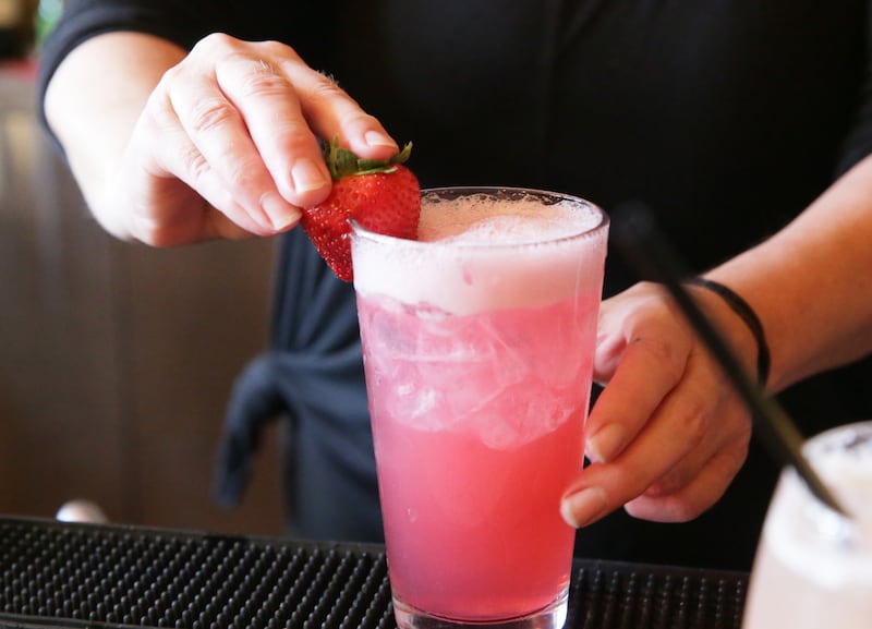 A bartender makes a drink.