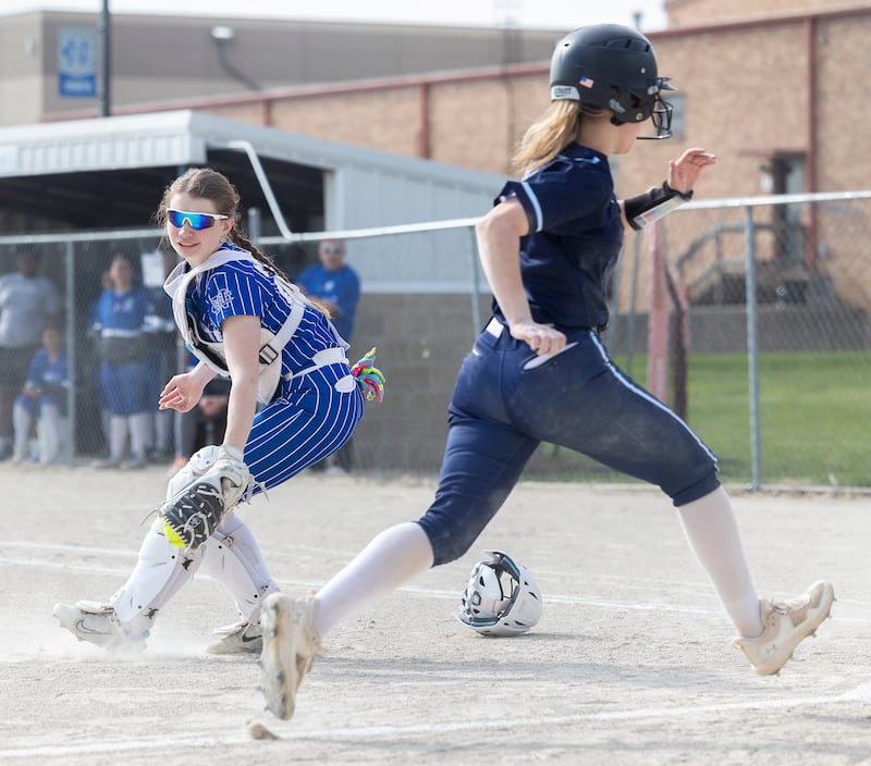 Newman’s Kaylee Benyo reaches back but was too late to tag out Bureau Valley’s Sadie Bailey who scored the first run for the Storm Wednesday, April 16, 2025.
