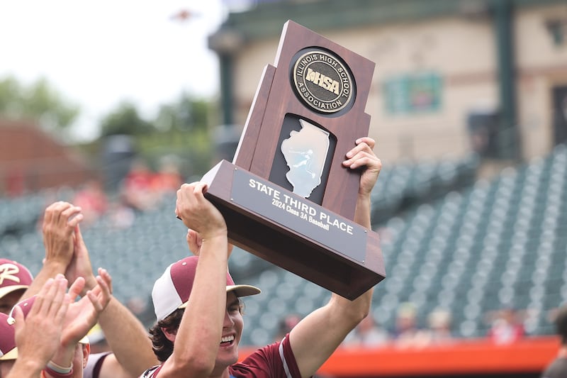 Morris’ A.J. Zweeres holds up the 3rd place trophy after their 1-0 8 inning win against Highland in the IHSA Class 3A 3rd place game on Saturday June 8, 2024 Duly Health and Care Field in Joliet.