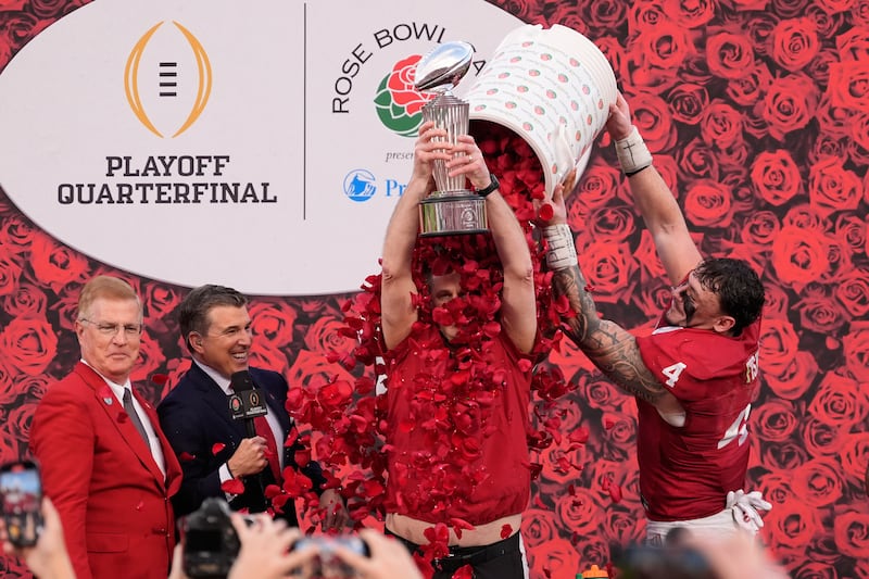 Indiana head coach Curt Cignetti holds the winner's trophy as he is doused with rose pedals by linebacker Aiden Fisher (4) after a win over Alabama in the Rose Bowl College Football Playoff quarterfinal game Thursday, Jan. 1, 2026, in Pasadena, Calif. (AP Photo/Mark J. Terrill)