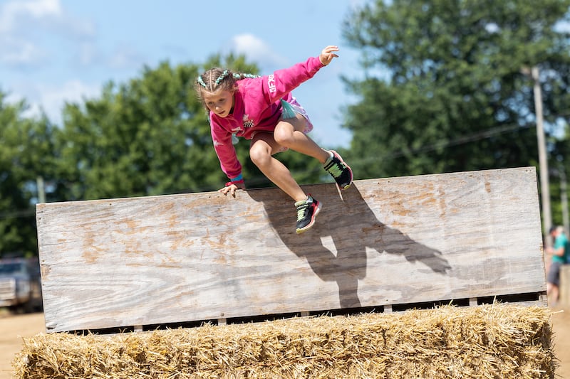 Addelynn Rombout, 8, of Milledgeville soars over an obstacle Saturday, Aug. 10, 2024 in the Ninja Farmer course at the Carroll County Fair. Kids could sign up to race the course with the top two finishers taking home a medal and everyone receiving a free ice cream.