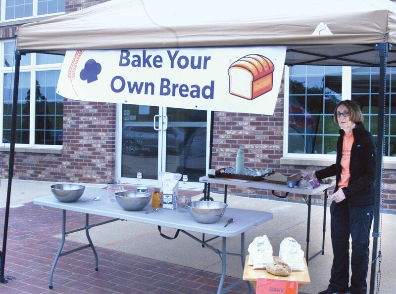 Volunteer Julie Tucker helps at the "Bake Your Own Bread" booth by the Windmill Cultural Center in Fulton during the 25th anniversary celebration in Fulton on June 7, Two more baking dates have been set where people can purchase a bag of stone ground flour - from the de Immeigrant Windmill - mix it up, knead it into dough and drop in the oven at the Windmill Cultural Center, from 10 a.m. to 2 p.m. on Saturday, July 5 and Saturday, Aug. 2.