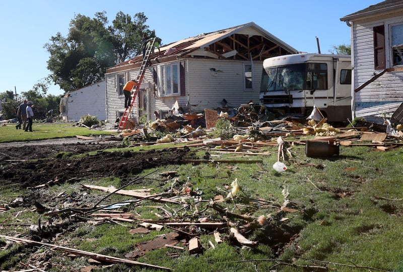 Inspectors climb on the roof of a home that sustained severe damage along Sunbury Drive on Friday, June 12, 2026 in Streator.