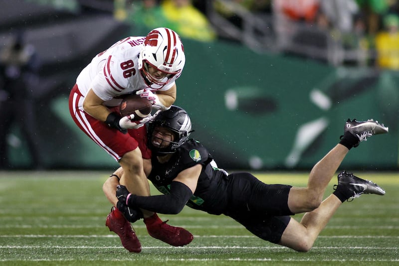 Wisconsin tight end Lance Mason (86) is tackled by Oregon defensive back Dillon Thieneman, right, during the second half of an NCAA college football game Saturday, Oct. 25, 2025, in Eugene, Ore. (AP Photo/Lydia Ely)
