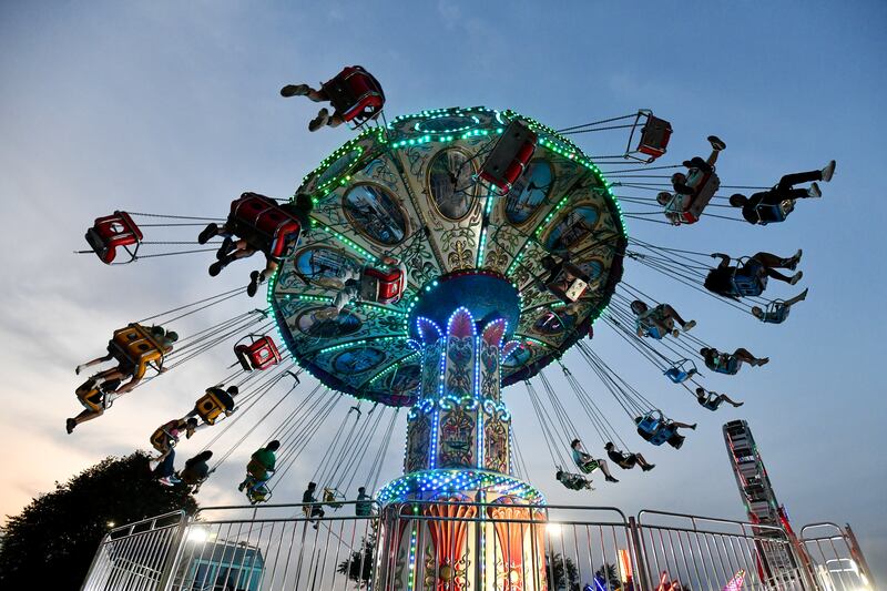 Fairgoers take a spin on the swings at the carnival during the 2023 Kankakee County Fair.