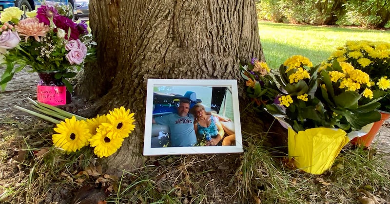 Memorial flowers, a photo and messages of love were placed outside the home of Gary Schmidt and Holly Schmidt on Friday, Oct. 3, 2025, on Oakland Drive in Sycamore. The Schmidts, shown in the photo, were found dead in their home on Tuesday, authorities said.
