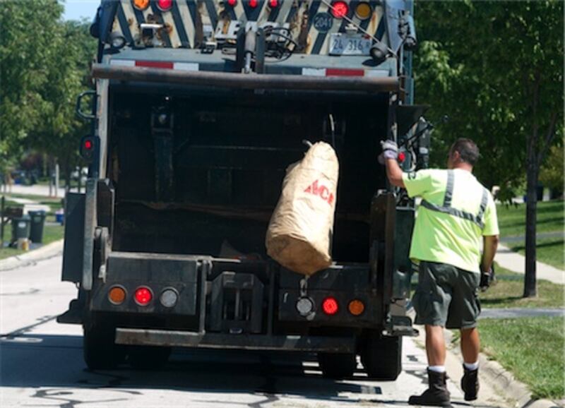 A 2012 Northwest Herald file photo shows a Groot Industries worker tossing yard waste into a truck in Cary's Foxford Hills subdivision.