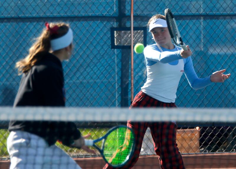 Marian Central’s Julia Lukey returns the ball as her teammate, Jenna Remke, watches on Thursday, Oct. 23, 2025, during the first day of the IHSA State Girls Tennis Tournament a tHoffman Estates High School.